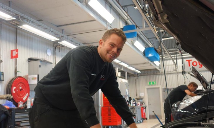 Fotografía de un chico mecánico trabajador en un taller Toyota