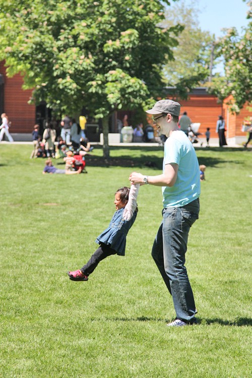 Un chico levantando a una niña de las manos 