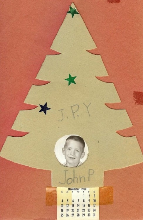 Pequeño pino de cartón con la fotografía de un niño en la parte inferior 