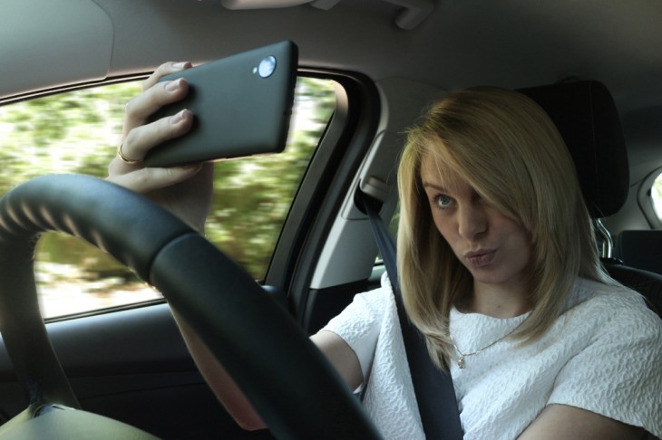 Chica tomándose una selfie mientras esta conduciendo 