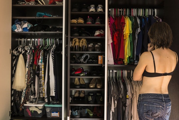 Una mujer parada frente a su closet pensando que se va a poner 