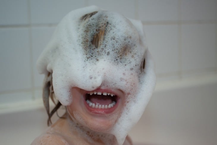 niño con el shampoo en la cara