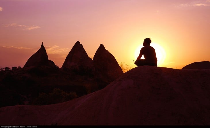 hombre meditando en la cima