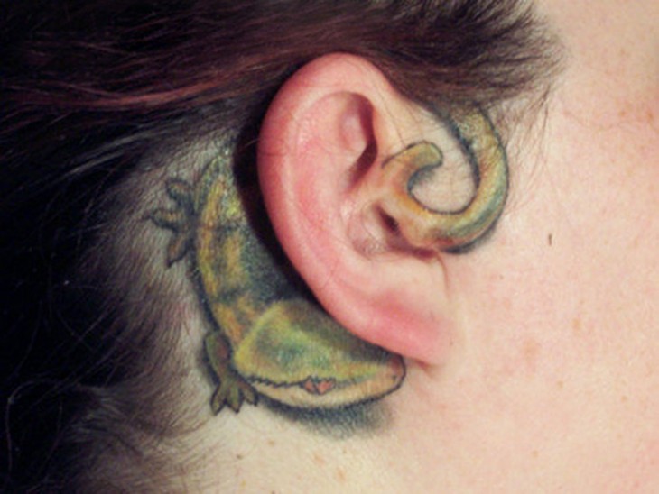 tatuaje de una iguana en la oreja