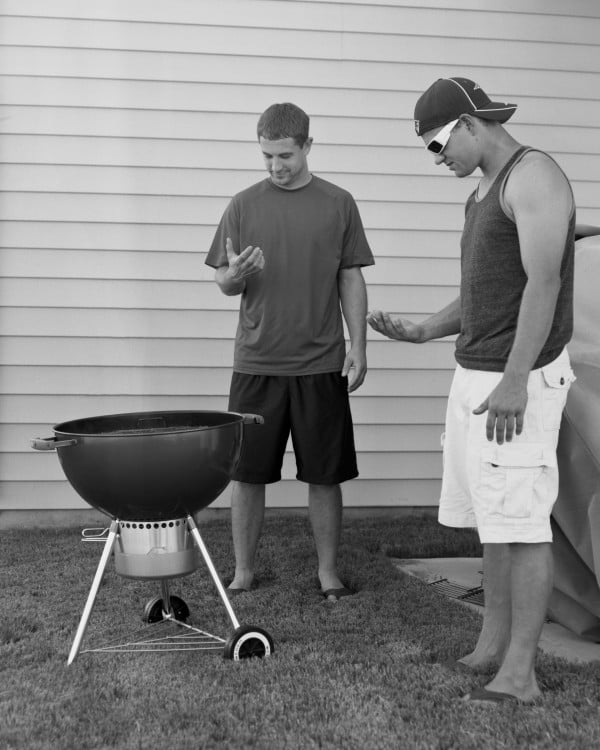 amigos haciendo carne asada mientras ven el telefono