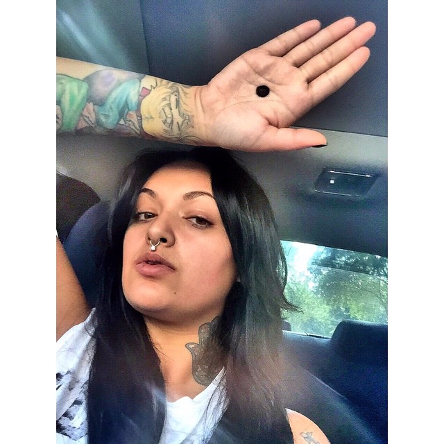 MUJER CON TATUAJES APOYANDO LA CAMPAÑA DEL PUNTO NEGRO