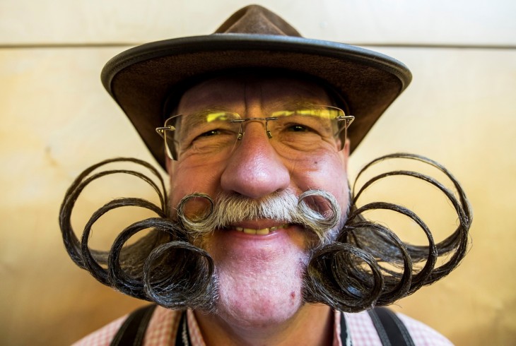 Cara de un hombre con un gran bigote y una gran barba peinada hacia arriba 