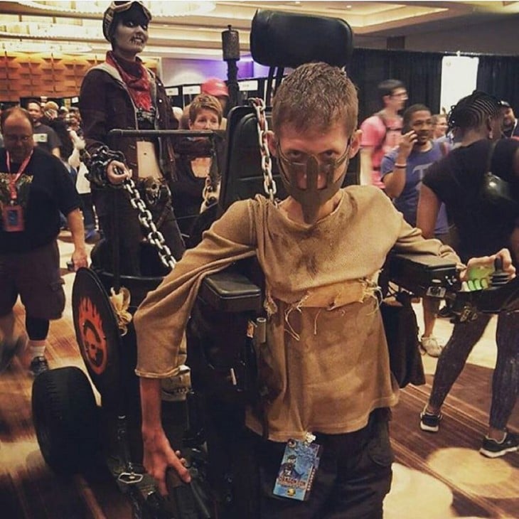 Niño con discapacidad disfrazado de Nux Bloodbag Chariot, Md Max: Fury Road 