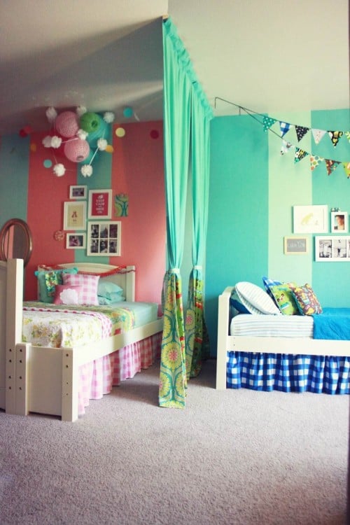 habitación dividida en dos partes por una cortina verde con una mezcla de colores verde, azul y rosa 