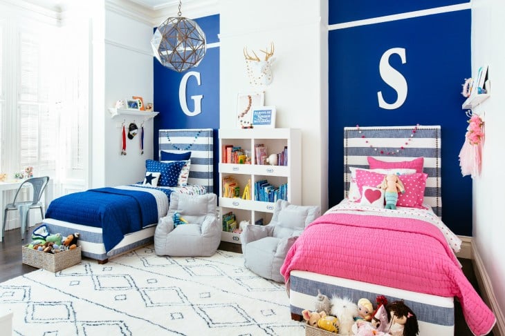 habitación con dos camas decoradas en color azul rey y rosa 
