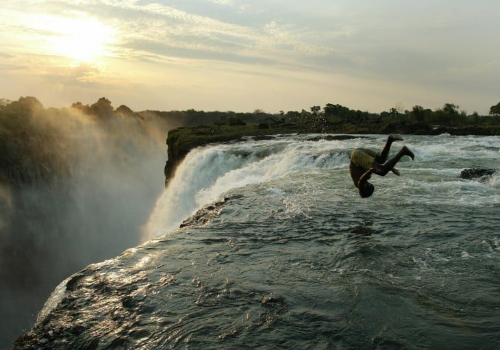 Persona a punto de lanzarse a la piscina del diablo en las cataratas victoria en África