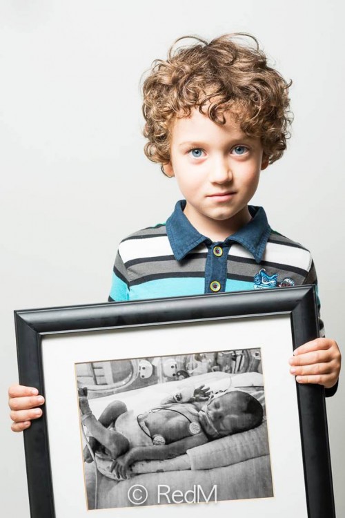 niño poniendo un retrato frente a él cuando fue un bebé prematuro 