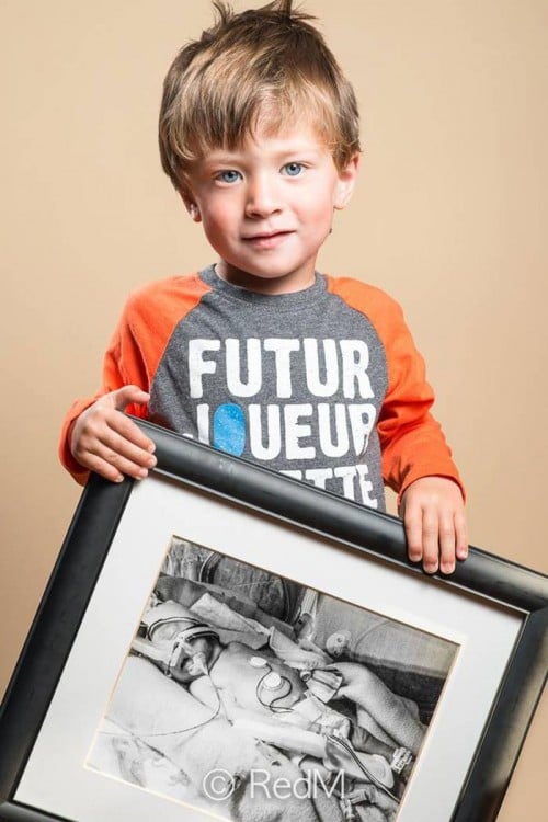 niño con un retrato de él cuando era bebé 