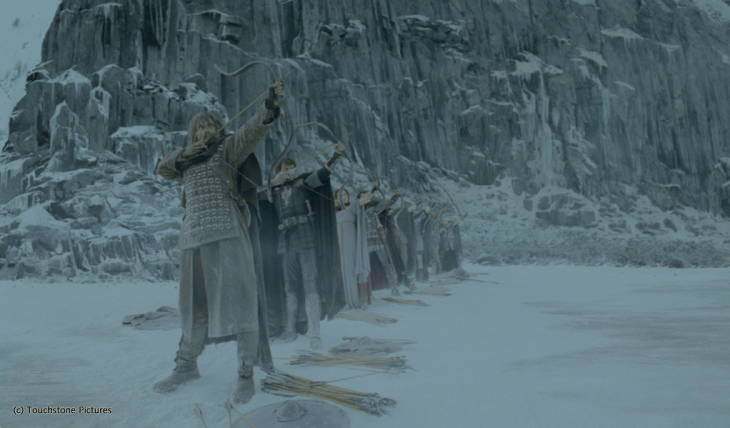 Personajes de la película el rey Arturo apuntando con un arco en una escena de nieve 