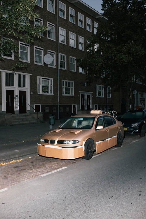 Carro estacionado en una calle tuneado con cartón y cinta adhesiva 