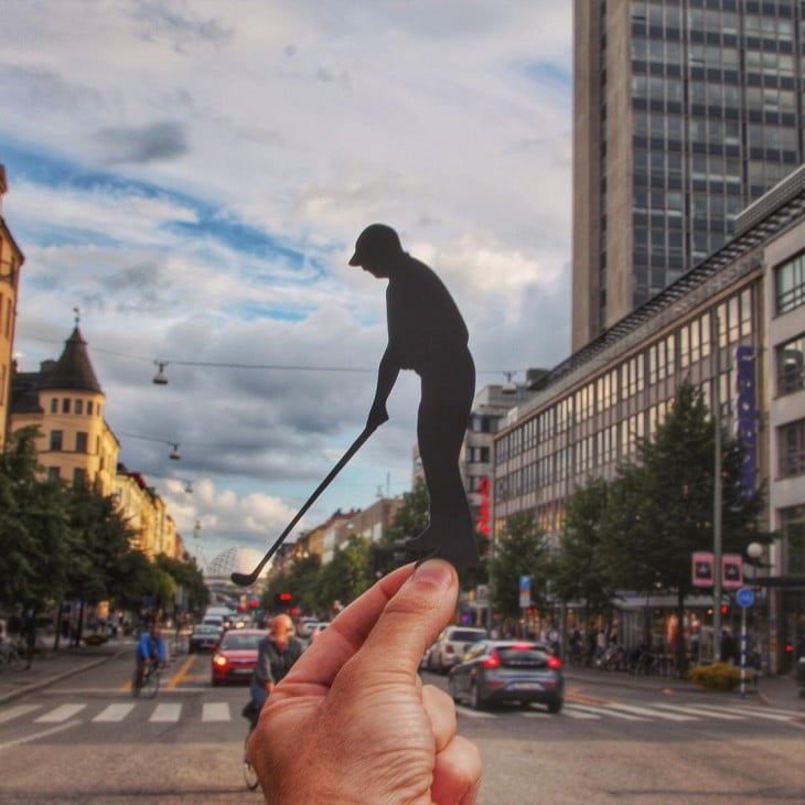 Recorte de papel en figura de un golfista simulando que el Arena Globen, Estocolmo es una pelota de golf 