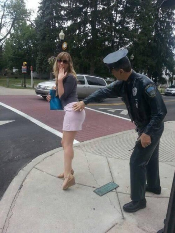 foto de una estatua de policía tocando un glúteo de una chica en medio de la calle 