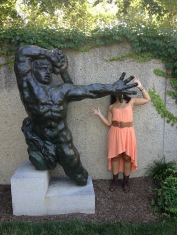 foto de una estatua que parece estar estampando a una chica contra la pared 