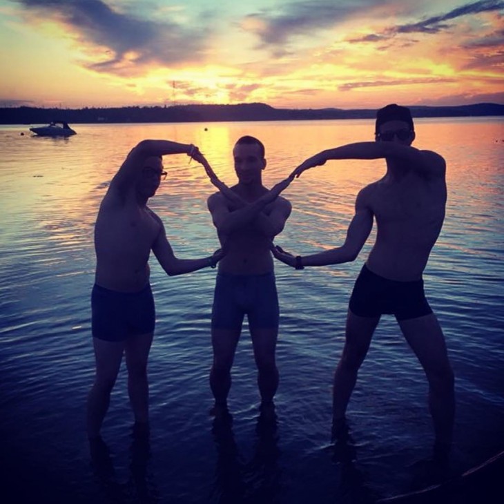 hombres imitando el simbolo de infinito en el atardecer del mar