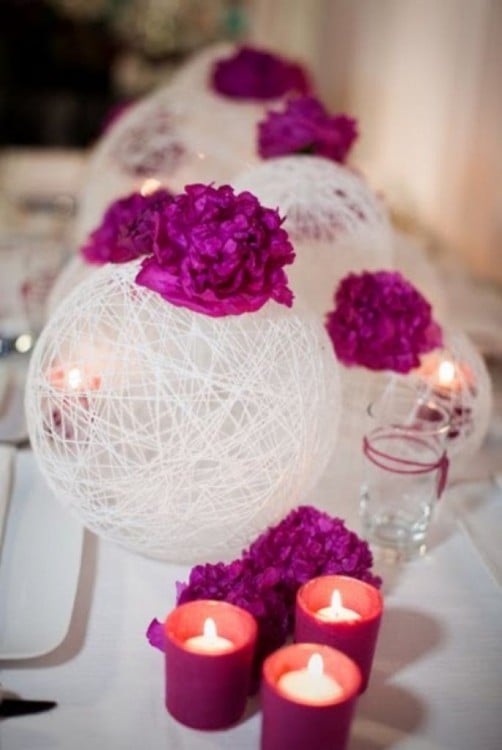 centros de mesa blancos con flores y unas veladoras en la mesa 