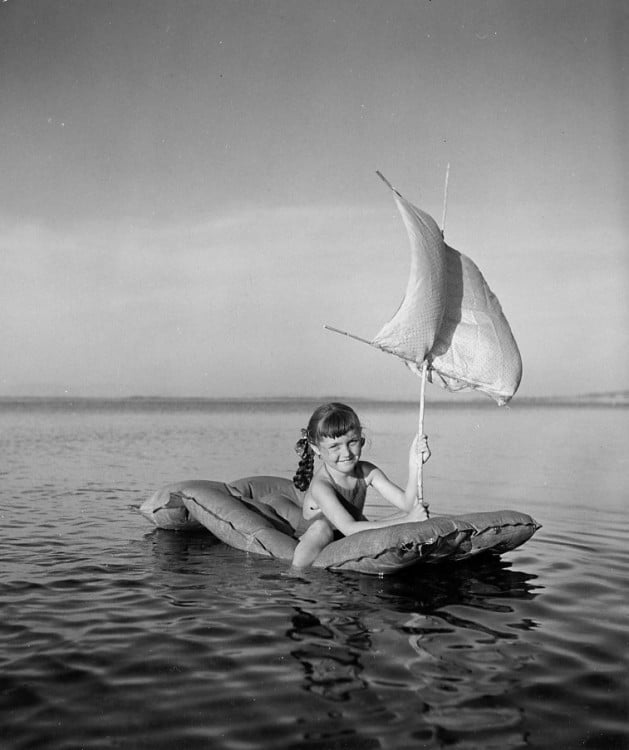 niña con un flotador en el rio o en el mar simulando un barco