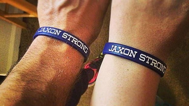 muñecas de los padres de Jaxon con sus pulseras "Jaxon Strong" 