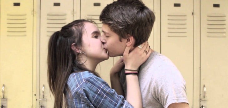 una pareja de dos adolescentes besándose 