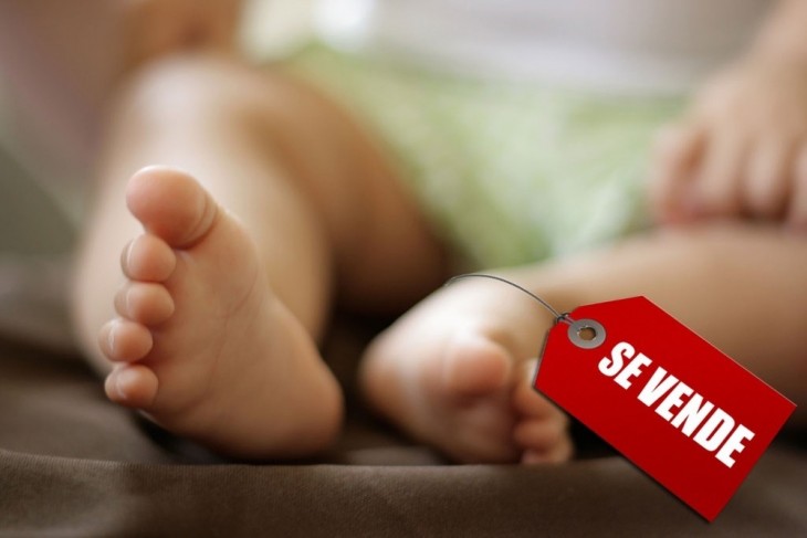 Pies de un bebé con una etiqueta de Se Vende 