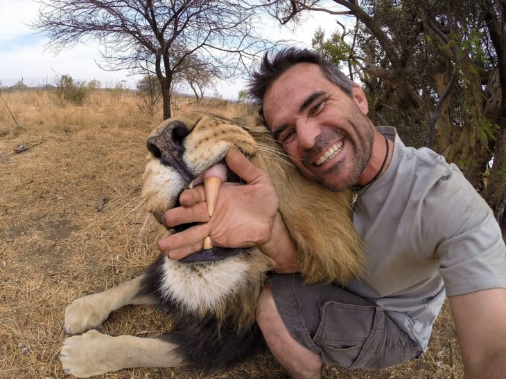 selfie de un hombre junto a un león 