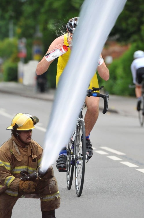 CICLISTA AL QUE EL BOMBERO LE AVIENTA EL AGUA