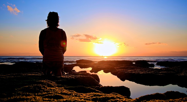 HOMBRE MIRANDO AL PONIENTE MIENTRAS SE OCULTA EL SOL EN ALGUN LUGAR DEL MUNDO