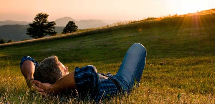 HOMEM NO PASTO RECUMBENT ALGUM LUGAR apreciando a vista