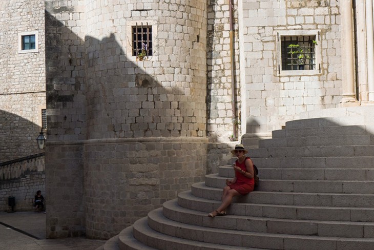 una chica sentada en unas escaleras en Dubrovnik 