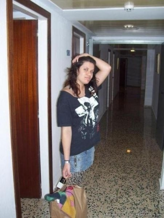 fotografía de una chica afuera de un cuarto con una bolsa de ropa en la mano 