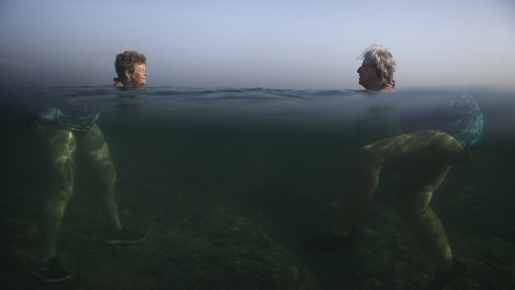 dos mujeres dentro del agua donde solo se ven sus cabezas 