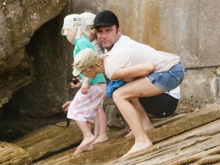 fotografía de unos padres junto a sus hijas cerca de unas piedras 