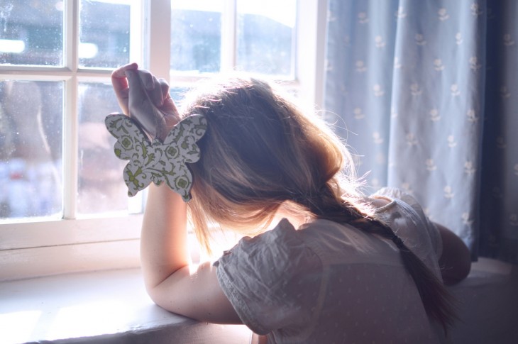 niño conpungida sobre la ventana