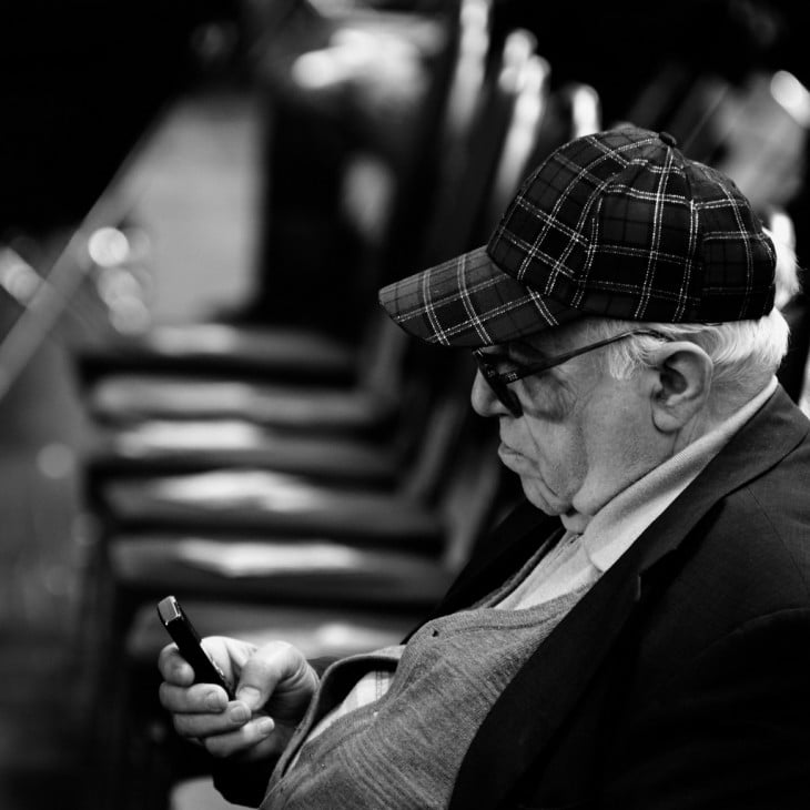 hombre viendo su celular en la calle