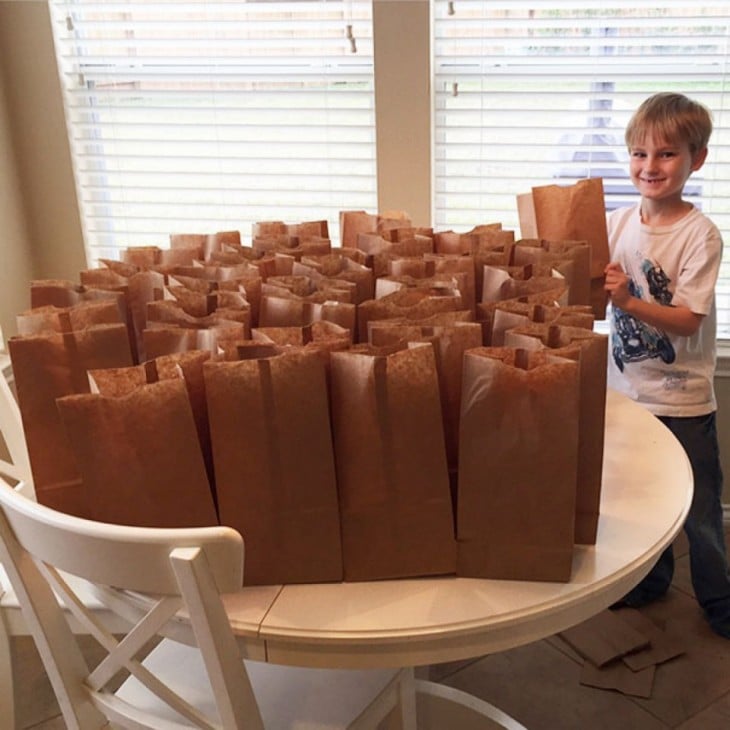 niño que apoya a los indigentes de su ciudad dándoles de comer