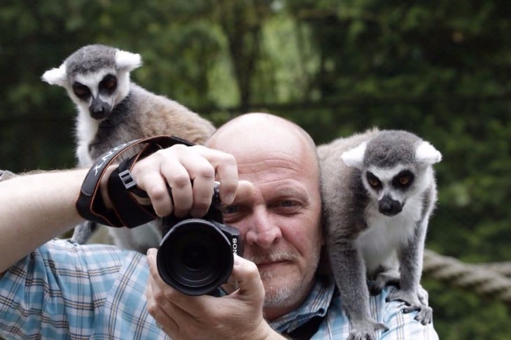 FOTOGRAFO CON MACACOS EN SUS HOMBROS