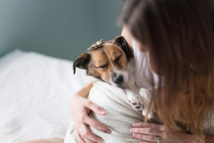 pareja se retrata con su perro como si fuera un bebé