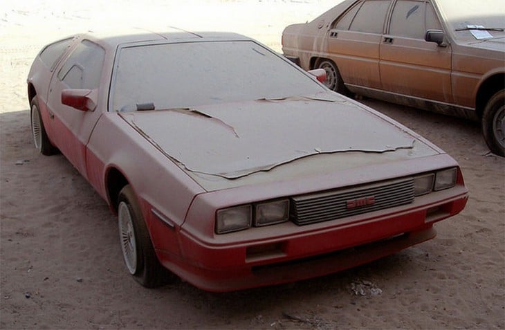 Carro DeLorean rojo abandonado en un estacionamiento en Dubái 