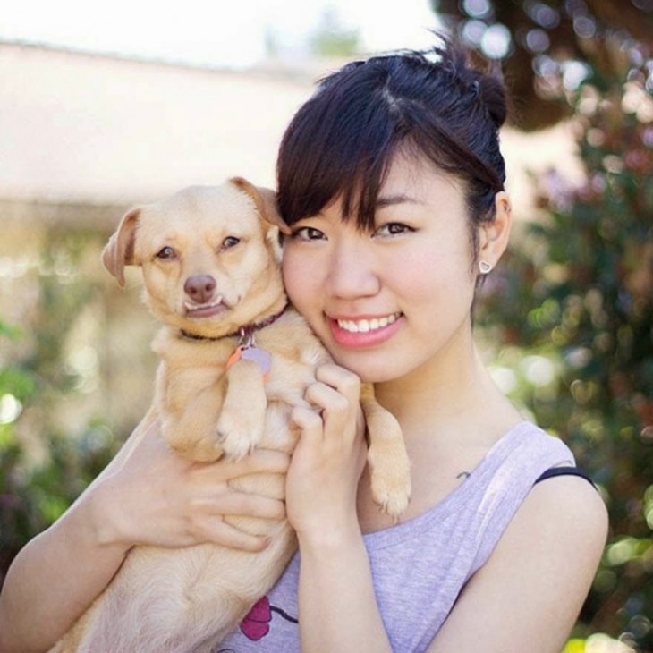 chica cargando a un perro en sus brazos 