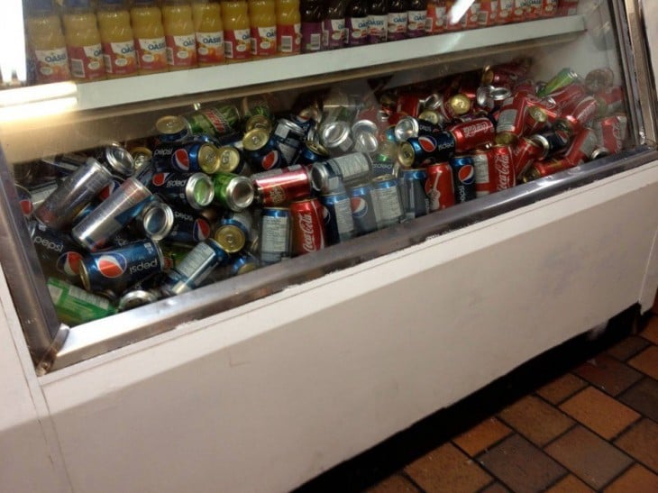 un refrigerador lleno de refrescos desordenados 