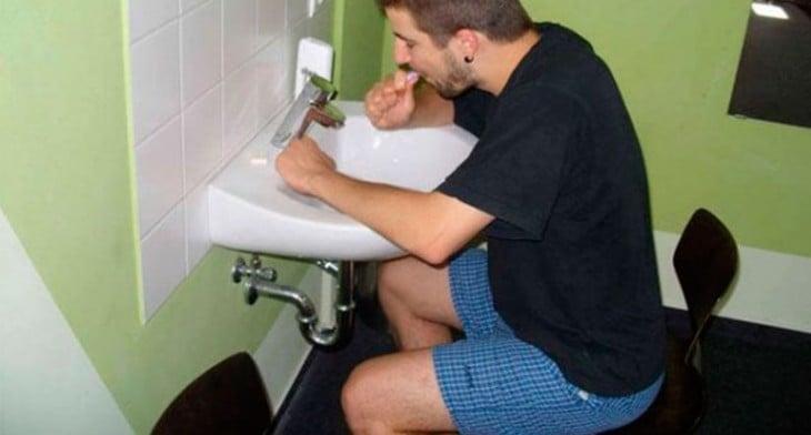 chico sentado en una silla lavándose los dientes 