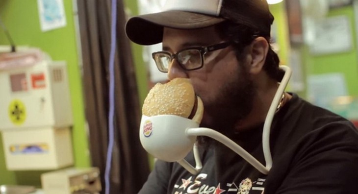 Chico sentado con un aparato comiendo una hamburguesa de Burger King 