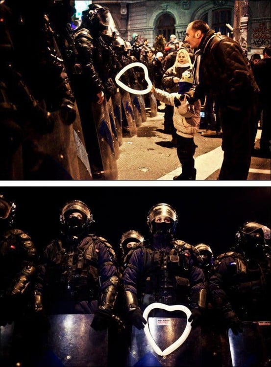 fotografía de un niño rumano que entra un globo en forma de corazón a un policía 