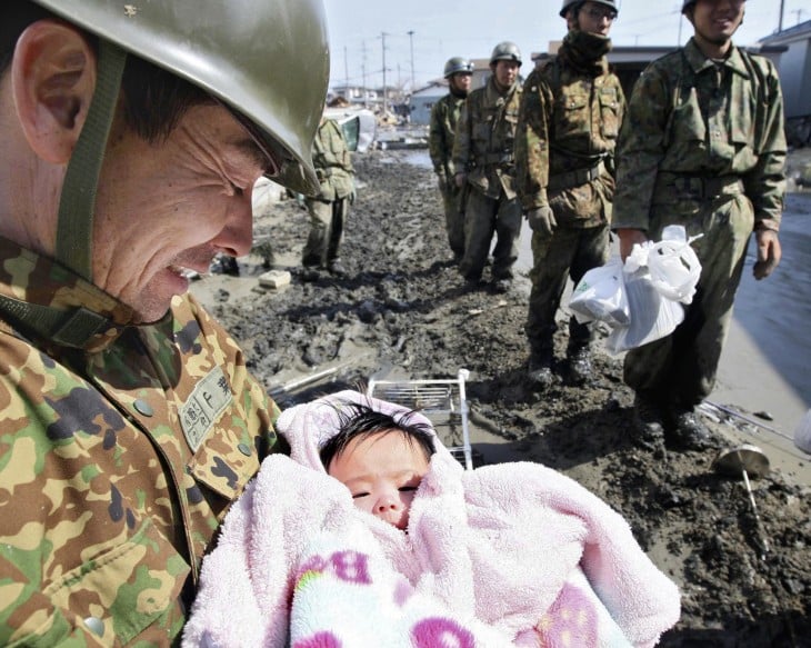 foto de un soldado con una bebé recién rescatada de entre los escombros durante un tsunami en Japón