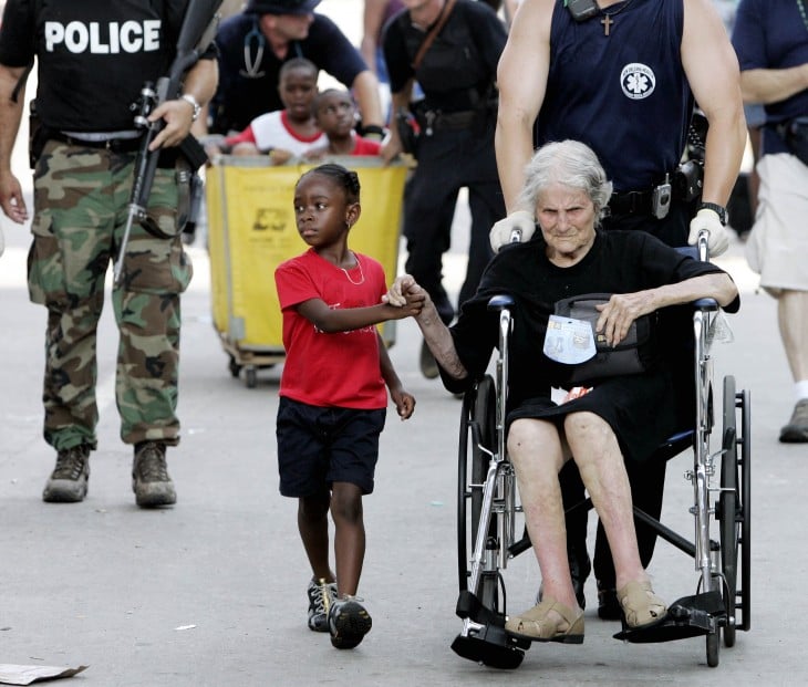 niña y una anciana víctimas de un huracán tomadas de la mano 