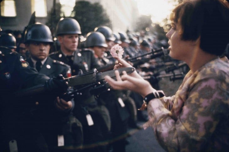Pacifista pone una flor en las escopetas de unos policías en vietnam 